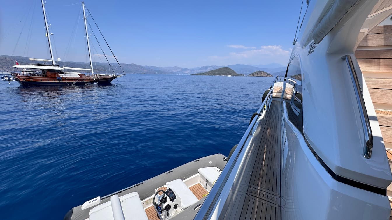 Göcek yakınlarındaki çam ormanlarıyla çevrili korunaklı bir koyda kıçtan kara demirlemiş Princess Y78 motor yatı — Throne Voyages'ın Likya Kıyıları mavi yolculuk bölümü.